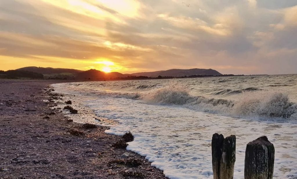 Orange sun dipping behind Blue Anchor bay.