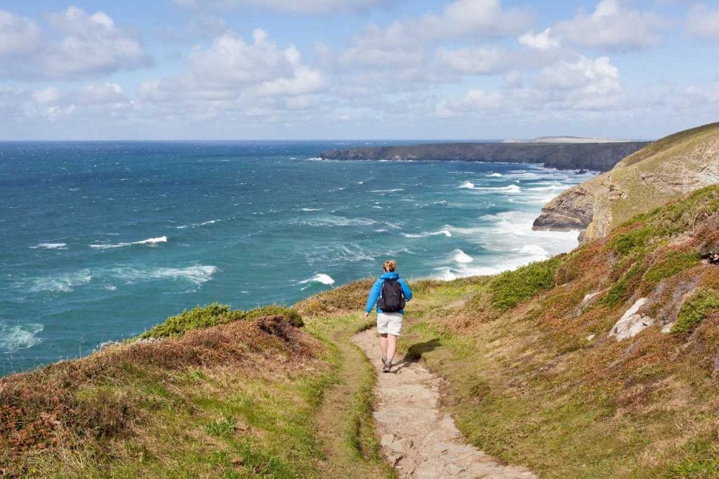Hiker walking the high cliff coastal path.