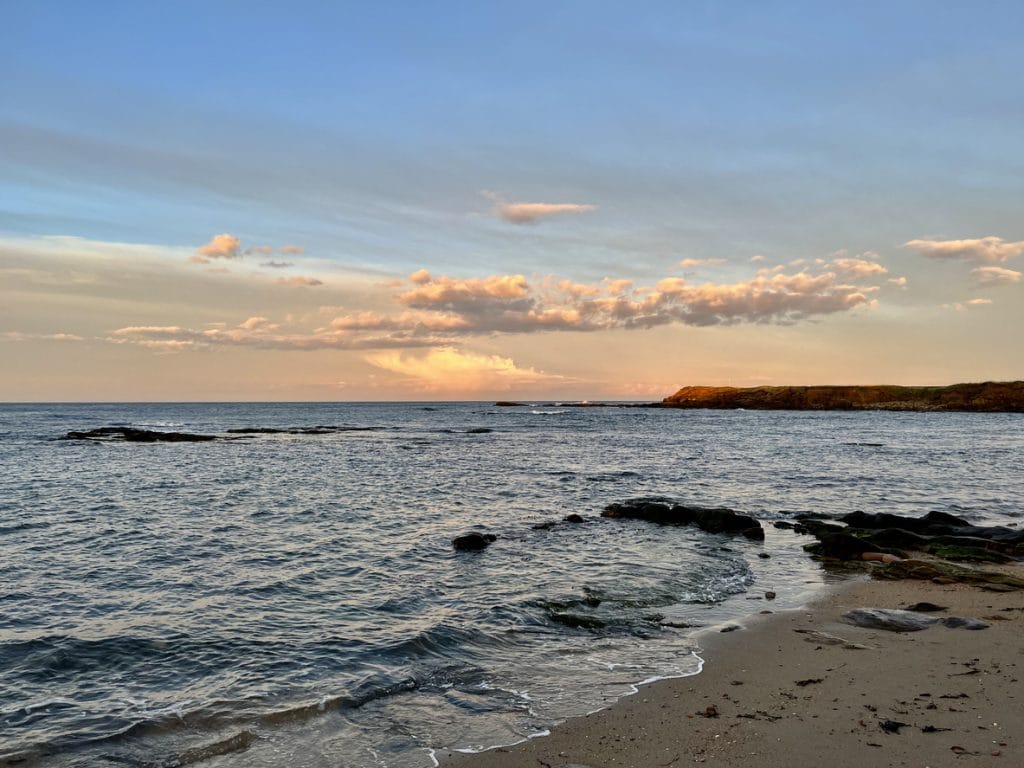 Beadnell Bay’s horseshoe-shaped beach with calm turquoise waters