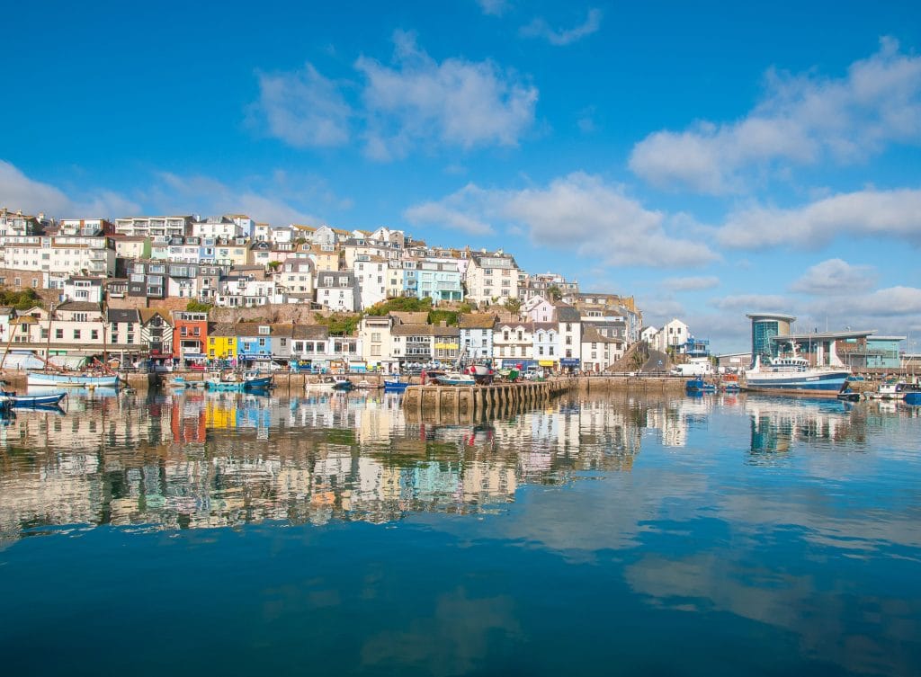 Brixham harbour view from the sea showing colourful cottages.