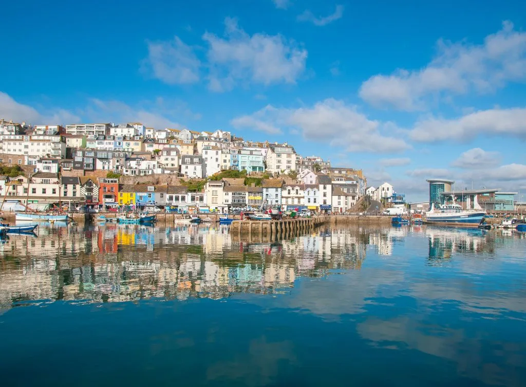 Brixham harbour view from the sea showing colourful cottages.
