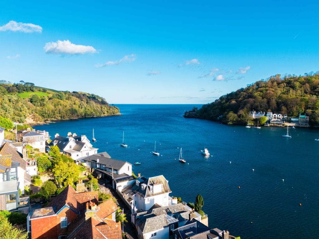 Riverside scene in Dartmouth showing the estuary and colourful waterfront buildings.