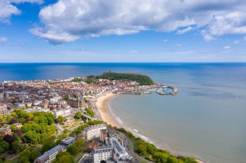 Aerial view of Scarborough South Bay with beach, promenade, and calm seas.