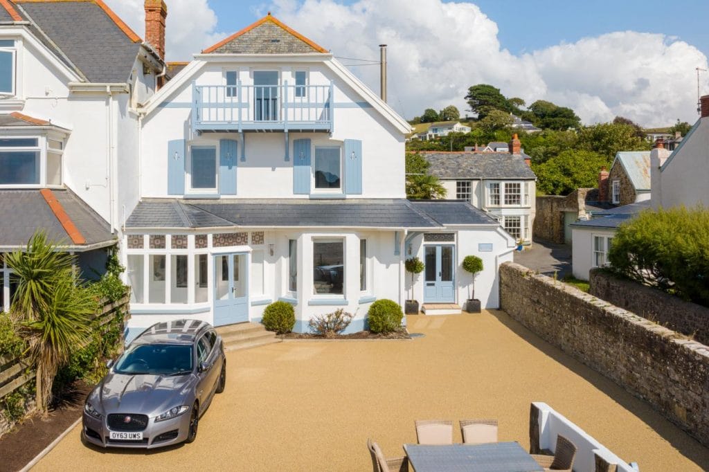 Beachfront house with parked car next to the sea