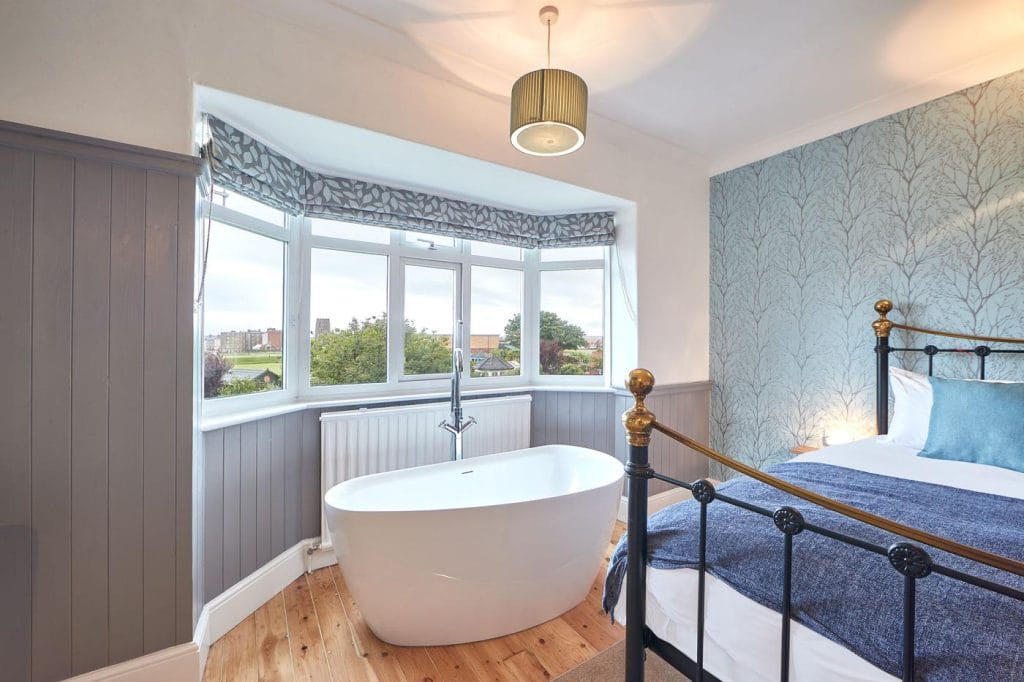 Main bedroom with free standing bath next to the window