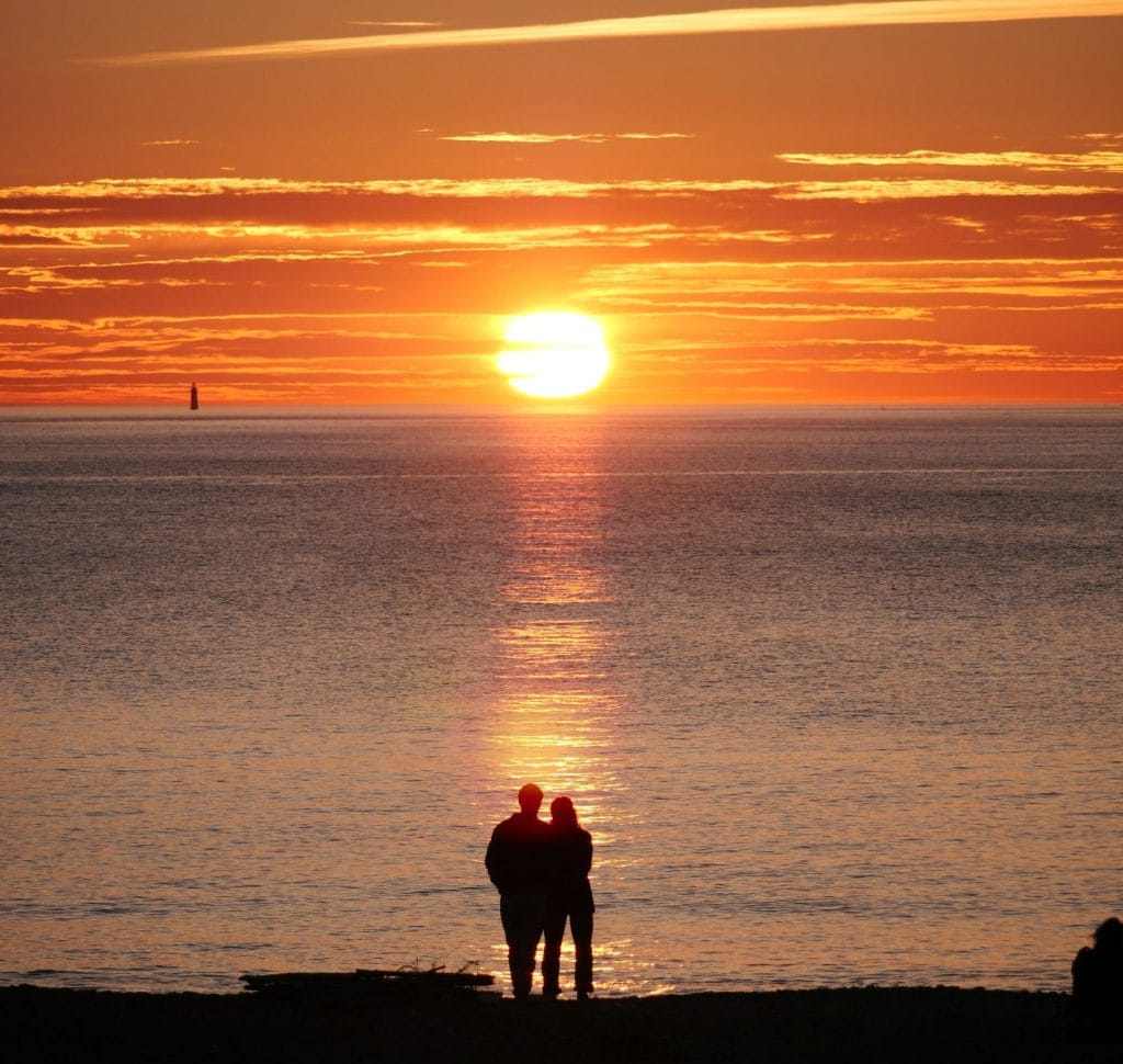 Couple watching sunset over the sea