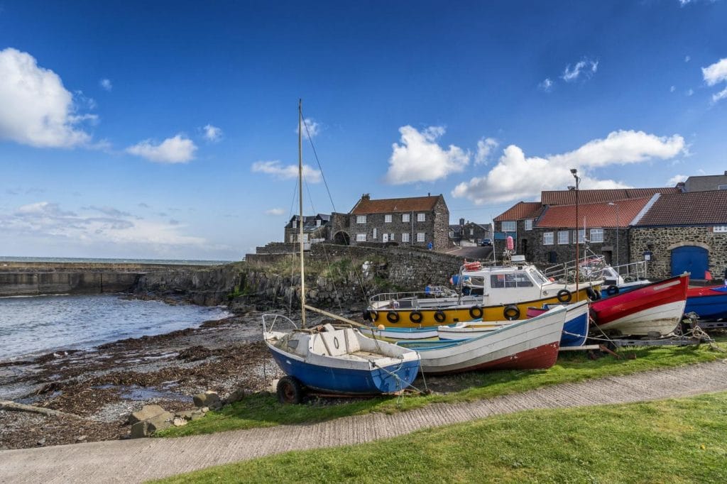 A row of fishing boats by the water in Craster