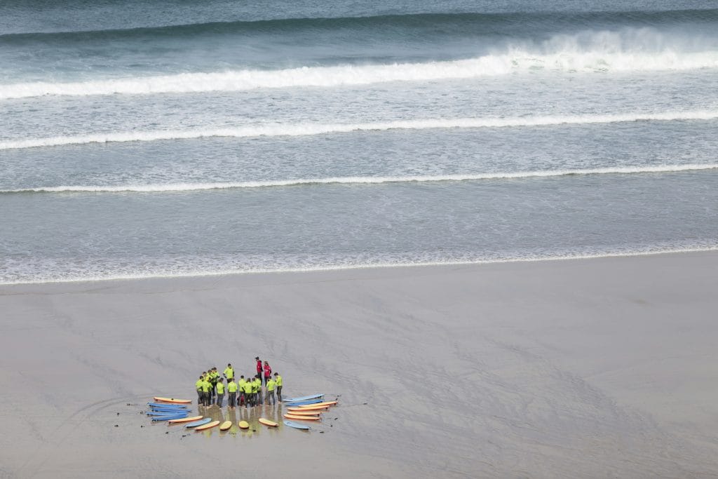A group taking surf lessons on Fistral Beach, Newquay