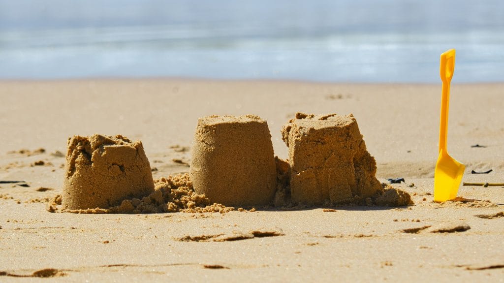 Yellow spade and sandcastle on the beach in Cornwall