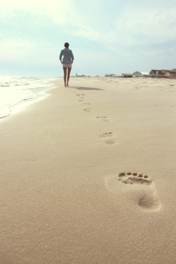 Footprints in the sand left by a walker in the distance