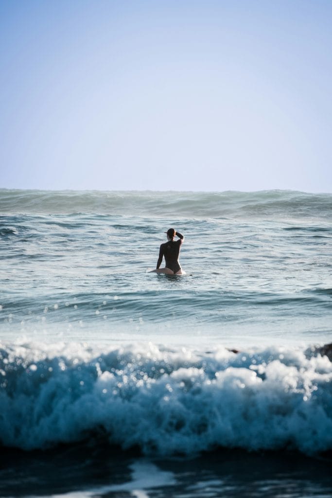 Lone surfer on his board looking out to sea