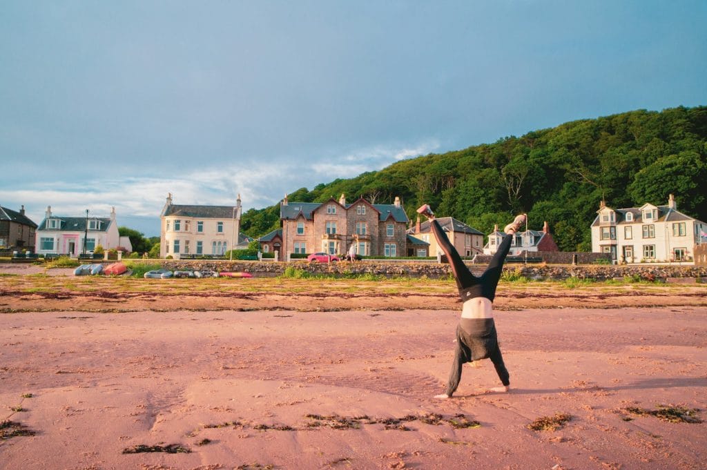 Girl performing a hand stand on the beach