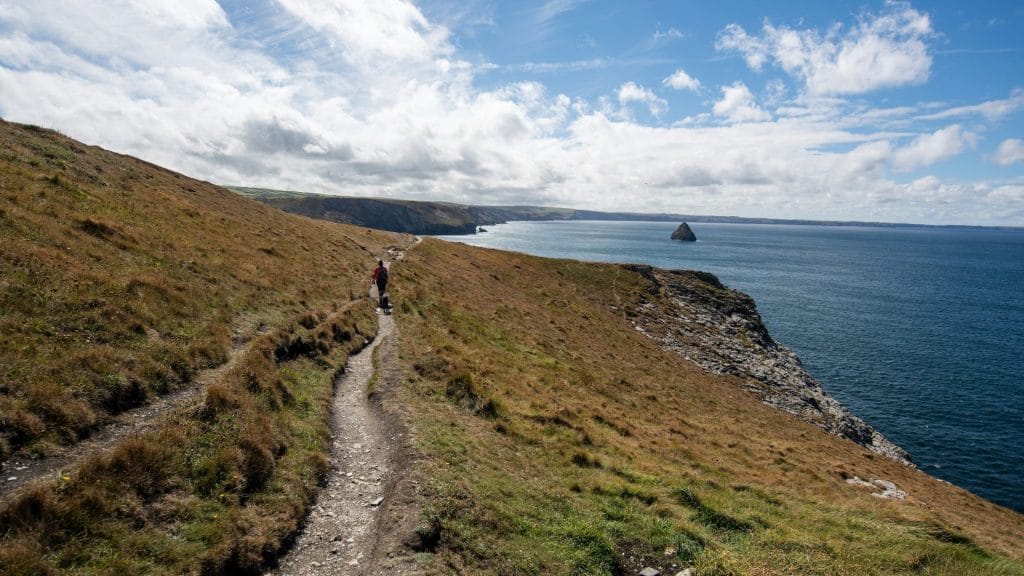 A lone walker on a coastal path next to the sea