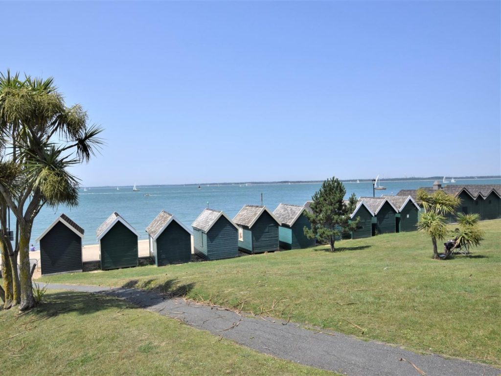 Row of colourful beach huts overlooking the bay at Cowes.