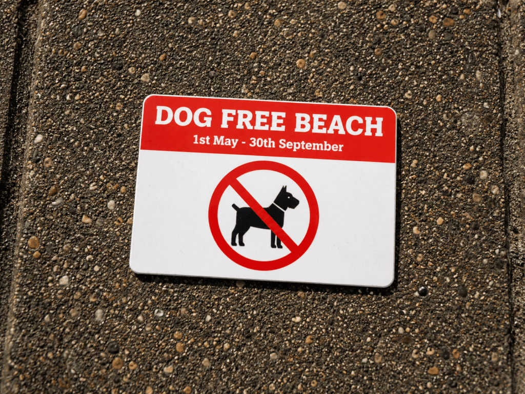 Sign on the beach showing dates that dogs are banned