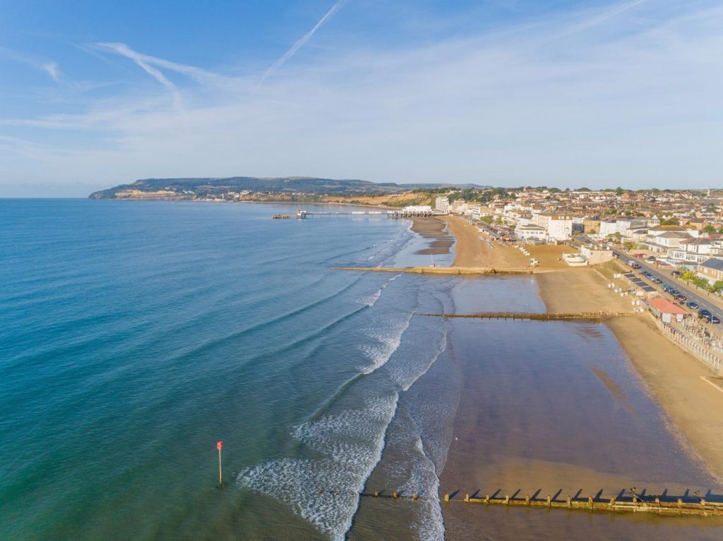 View of Sandown beach and wooden groynes on a sunny summer's day.