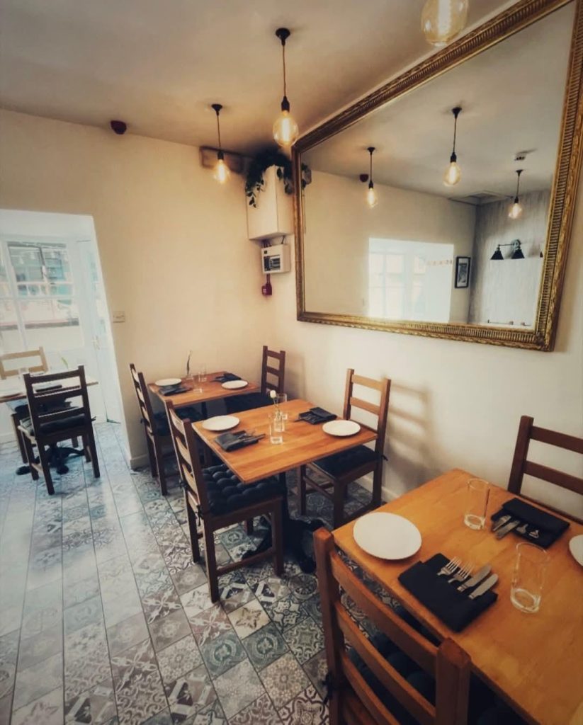 Row of tables inside Sandro's intimate restaurant in Lyme Regis, Dorset.