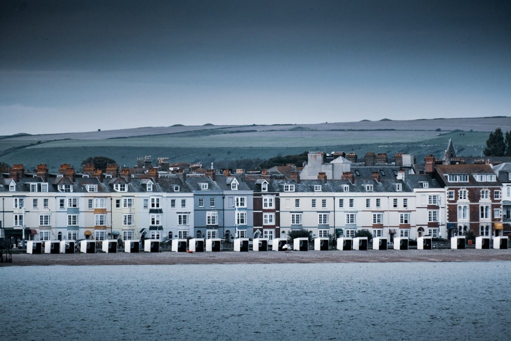 Row of seafront cottages in Weymouth on a cloudy day.