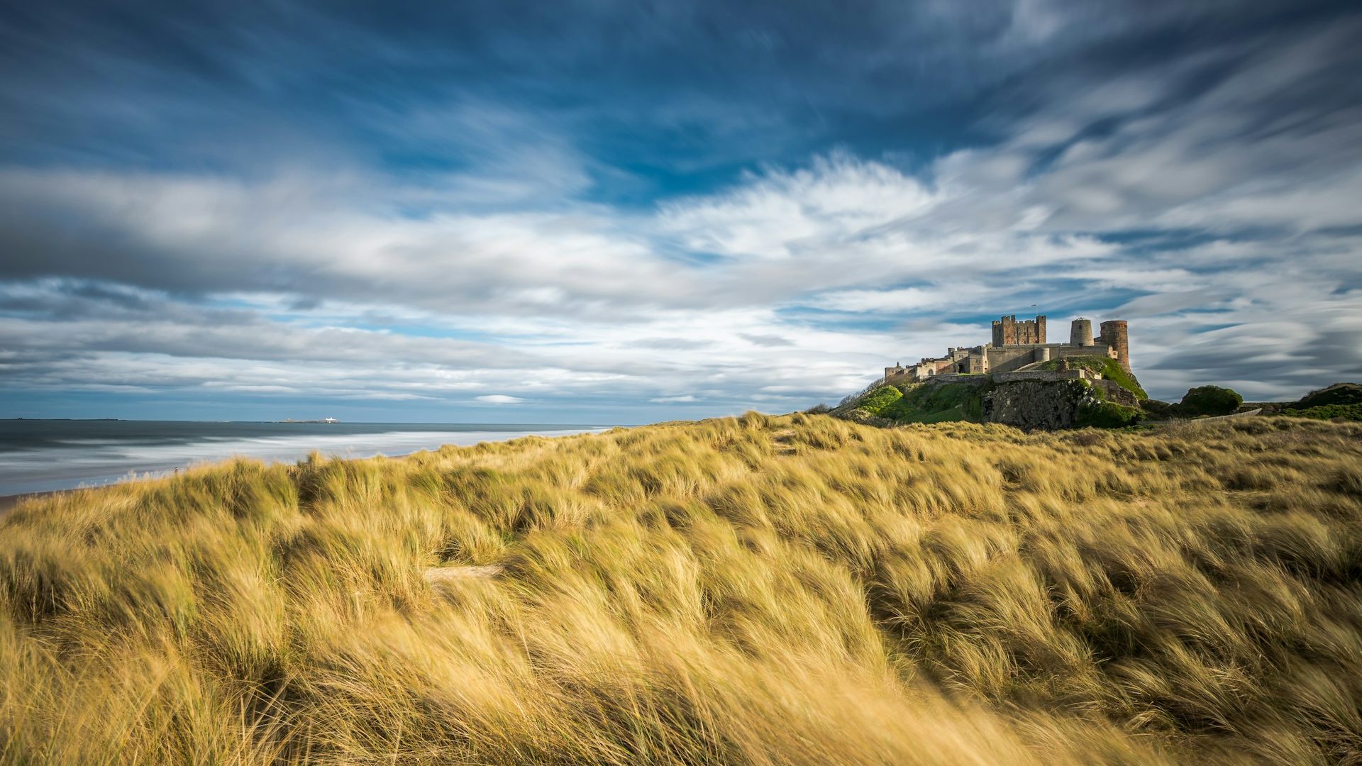 Picturesque view of Bamburgh Castle overlooking the beach on the Northumberland Coast.