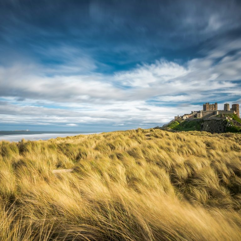 Picturesque view of Bamburgh Castle overlooking the beach on the Northumberland Coast.