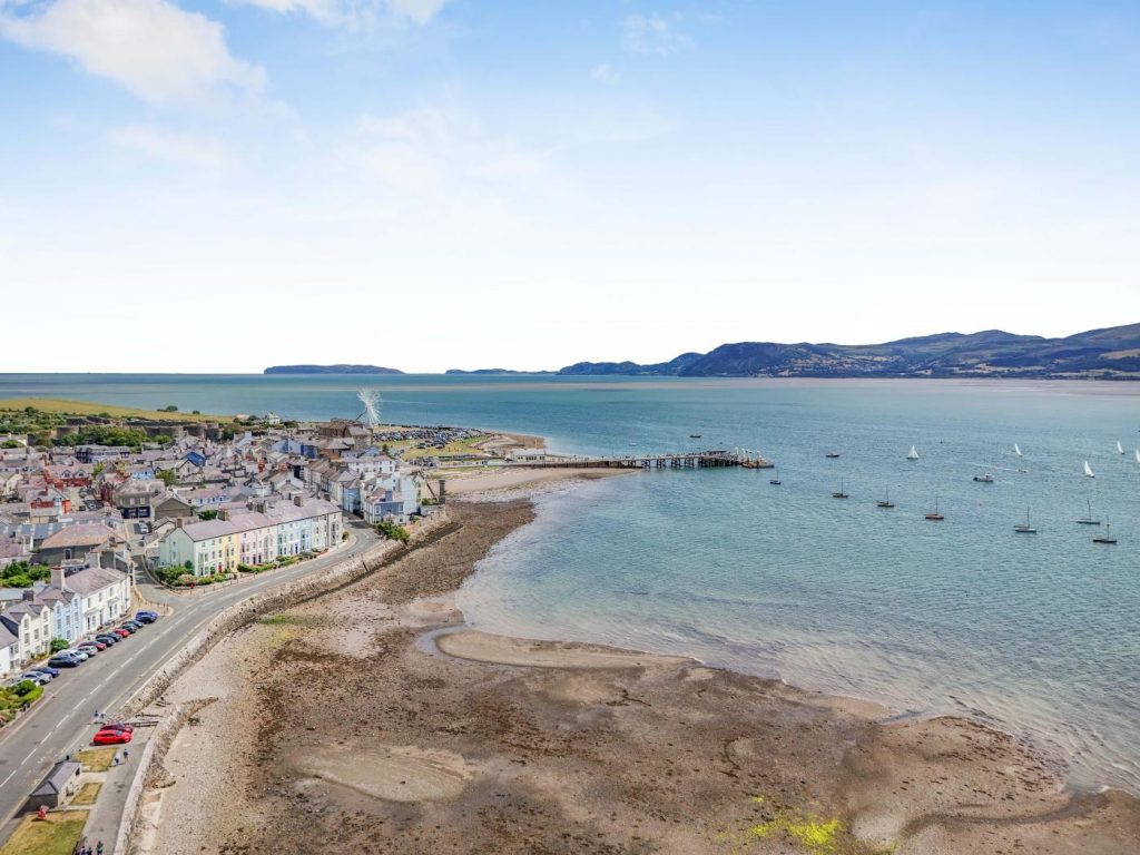 Beaumaris beach and harbour with cottages lining the shore.