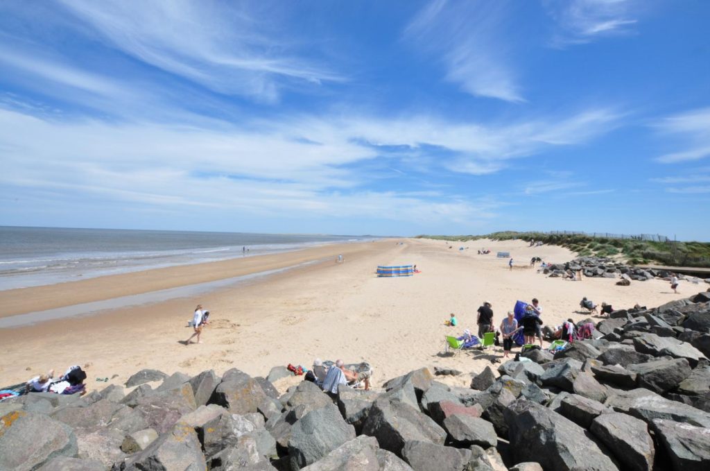 Families enjoying the sand on Brancaster Beach, Norfolk.