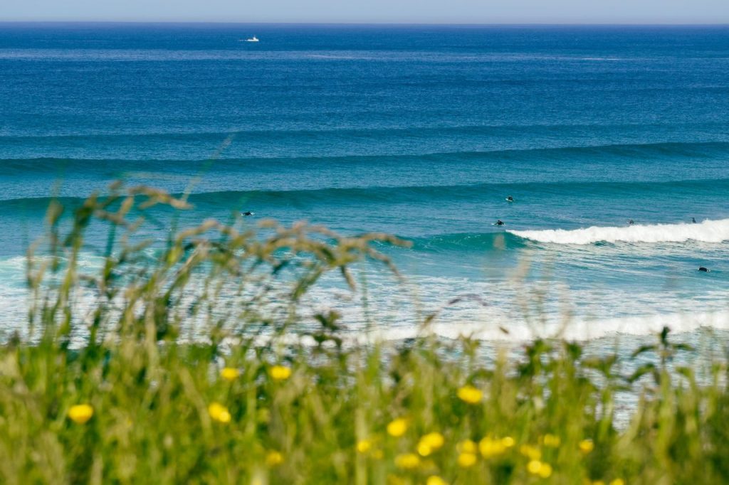 Surfers enjoying sets of clean waves on Fistral Beach in Newquay, Cornwall.