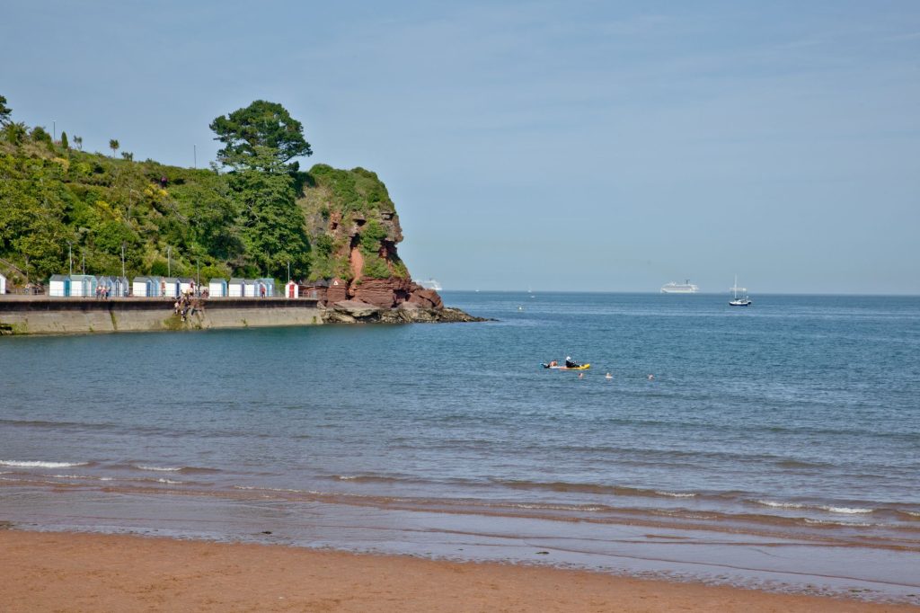 Beach huts in the distance on Goodrington Sands Beach, Paignton, South Devon.