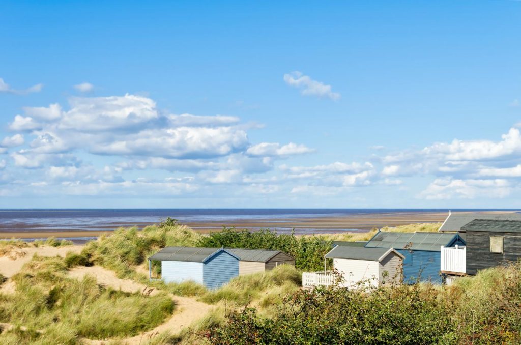 Beach huts in the sand dunes behind the beach at Old Hunstanton, Norfolk, UK.