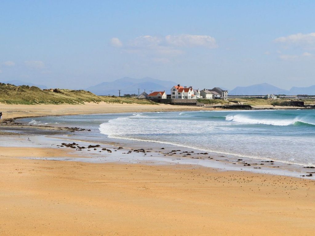 Small waves rolling in on Rhosneigr Beach in Anglesey, North Wales.