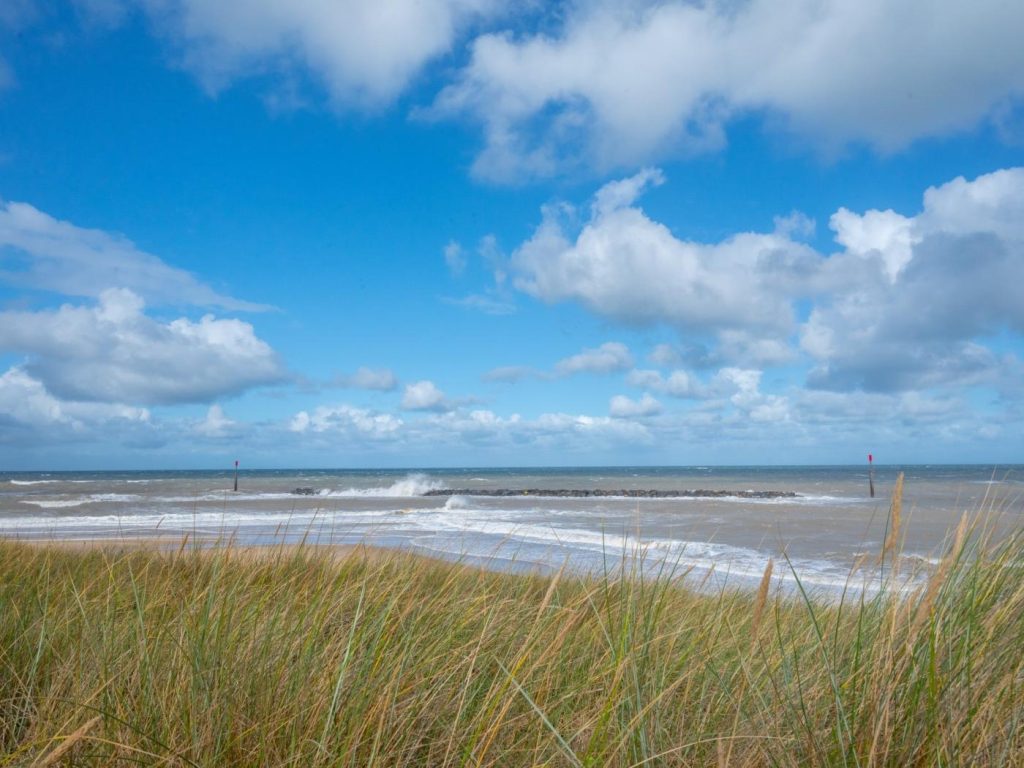 Looking across the grassy dunes at the beach in Sea Palling, Norfolk.
