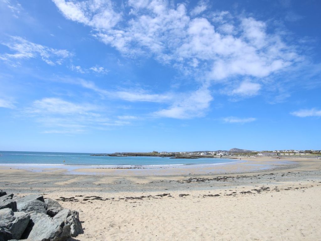 Large sandy beach at Trearddur Bay on a sunny day in summer.