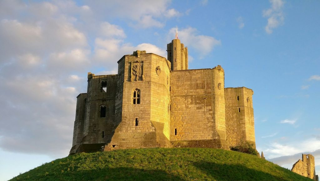 Sun shining on Warkworth Castle in Northumberland.