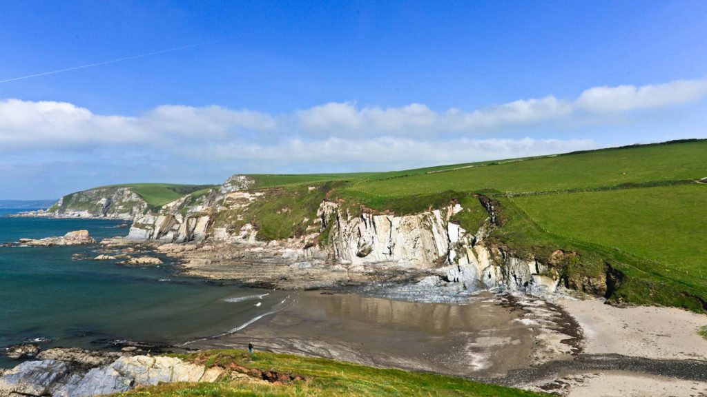 Rolling hills and cliffs behind Wembury Beach in South Devon.