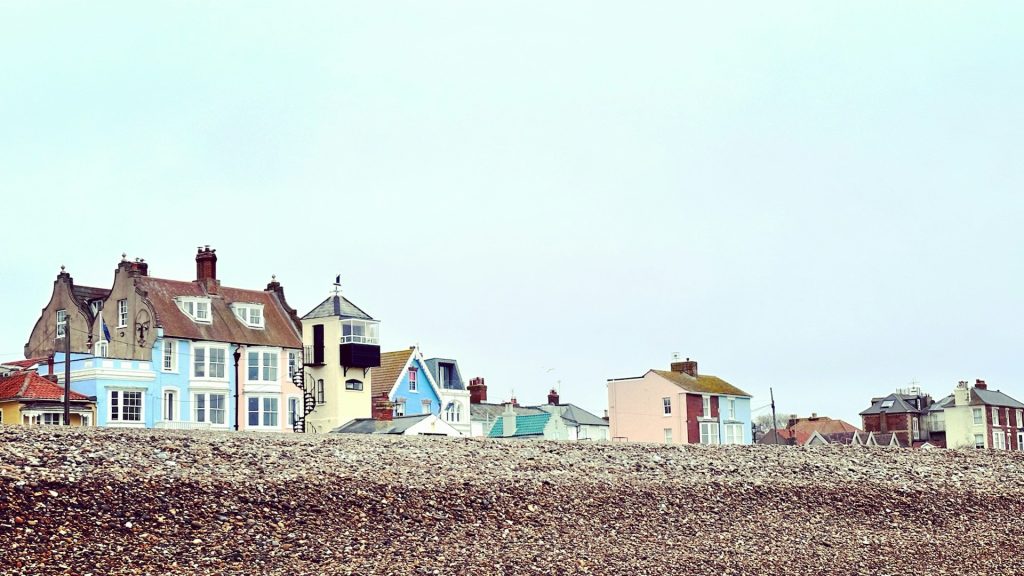 Empty shingle beach in Aldeburgh with cottages on the seafront.