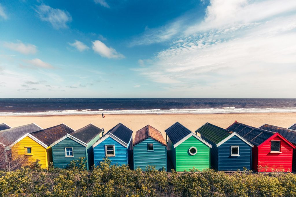 Colourful beach huts backing the empty beach in Southwold in autumn.