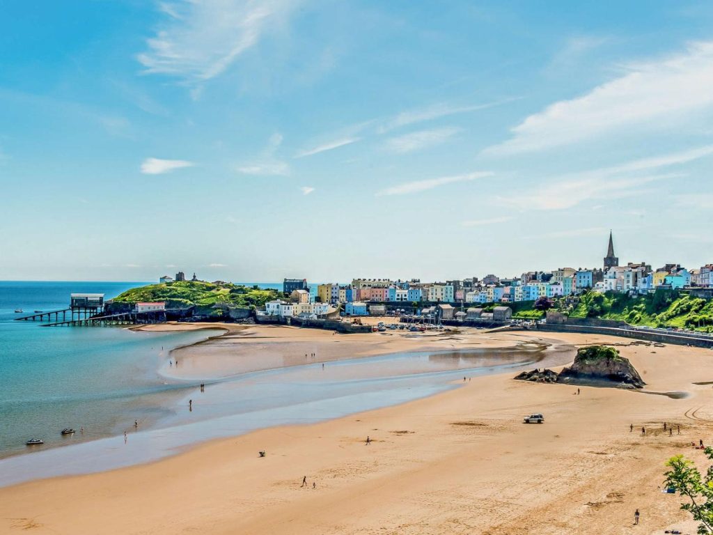Picturesque view of Tenby beach and harbour under a blue sky.