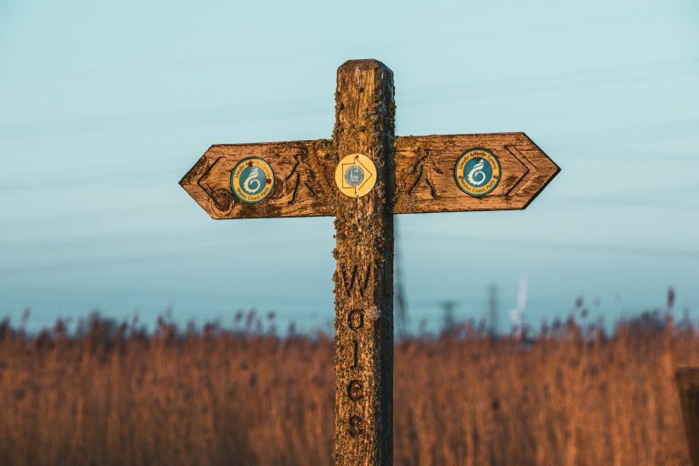Signage for the Wales Coast Path with the sea in the background.