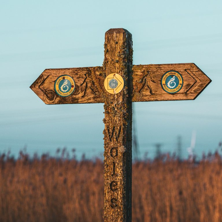Signage for the Wales Coast Path with the sea in the background.