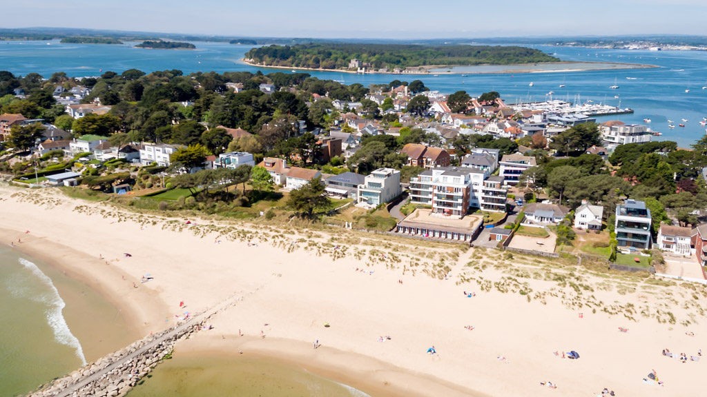 Aerial view of Sandbanks showing the sandy beach and seafront holiday homes.
