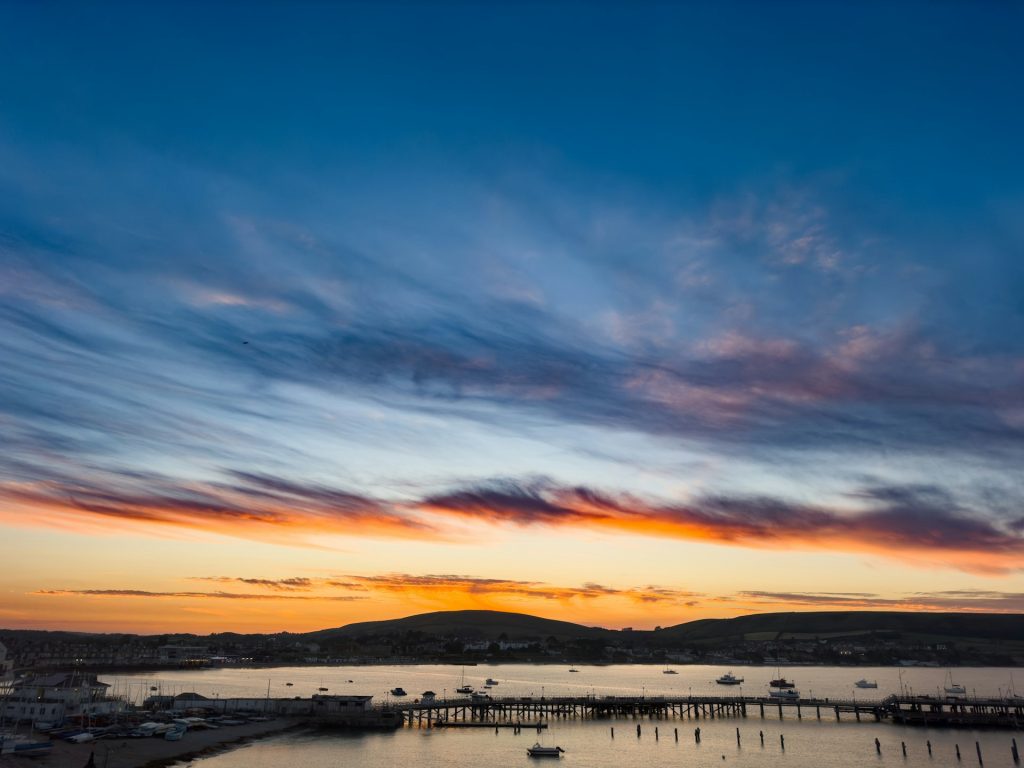 Picturesque colourful sky as the sun sets over Swanage Bay in Dorset, UK.