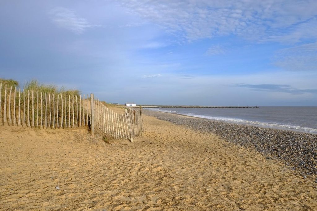 Wooden picket fence bordering the sand dunes on Walberswick Beach, Suffolk, UK.